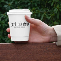 Una taza de Café du Jour en la mano, lista para disfrutar de tu café